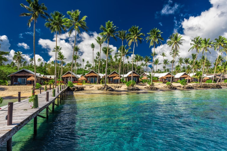 Amazing tropical beach with coconut palm trees and villas on Samoa Island