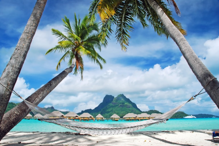 View of the Otemanu mountain , looking towards through the palms with hammock and the lagoon , Bora Bora , French Polynesia