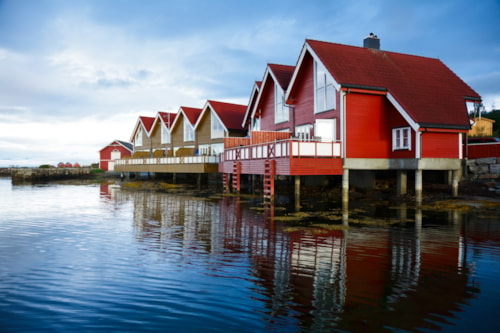 Red wooden cabins at campsite by the fjord in Molde, Norway